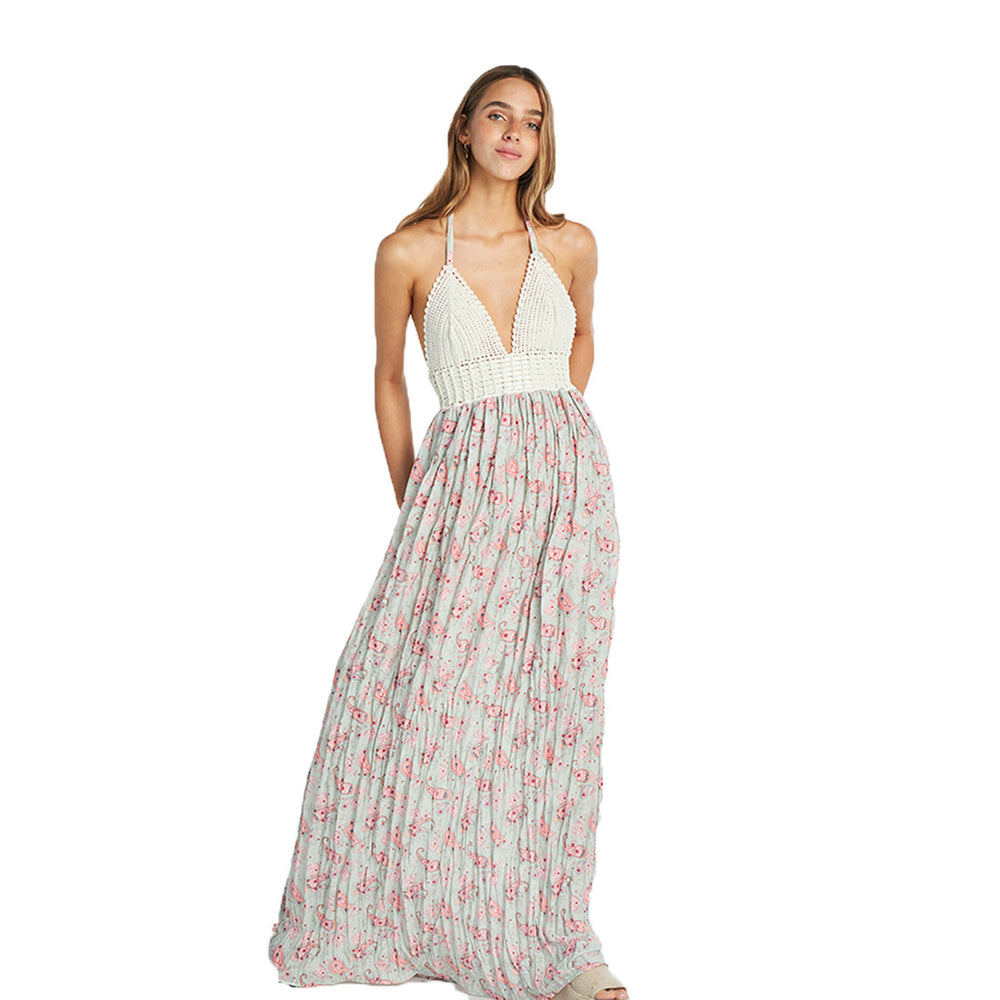 A woman wearing a floral print maxi dress with a V-neckline and sleeveless top.